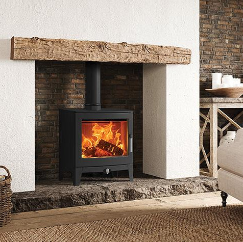 Cozy living room with a lit fireplace, plants, and furniture.